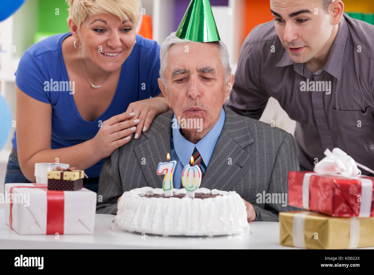 family together blowing in  the candles on birthday cake Stock Photo