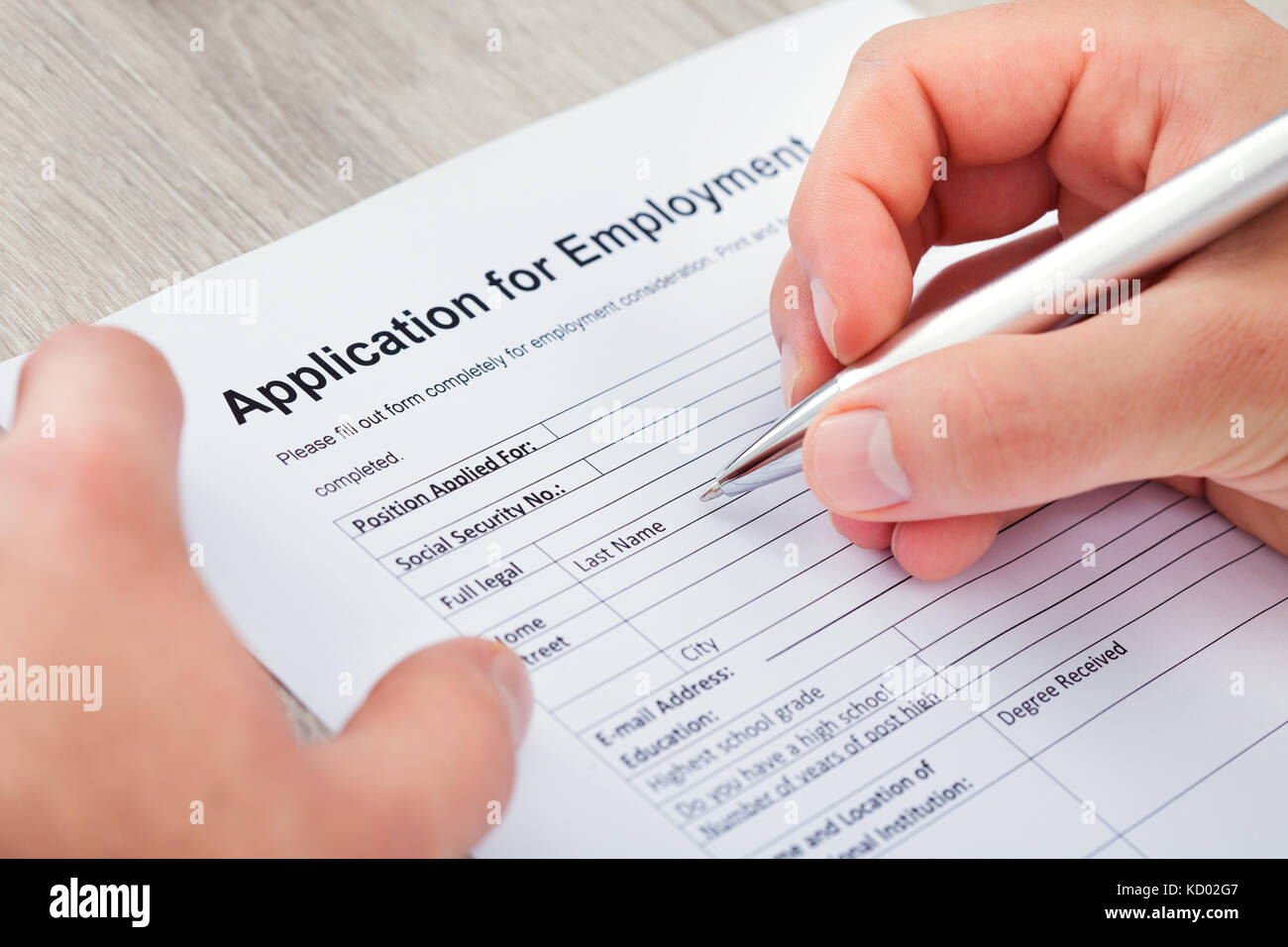 Close-up Of Hand Filling Application For Employment Stock Photo