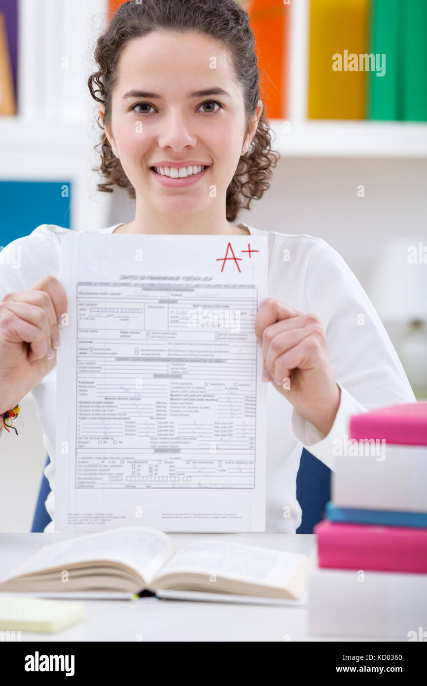 Teenager girl holding test paper with the best result Stock Photo - Alamy