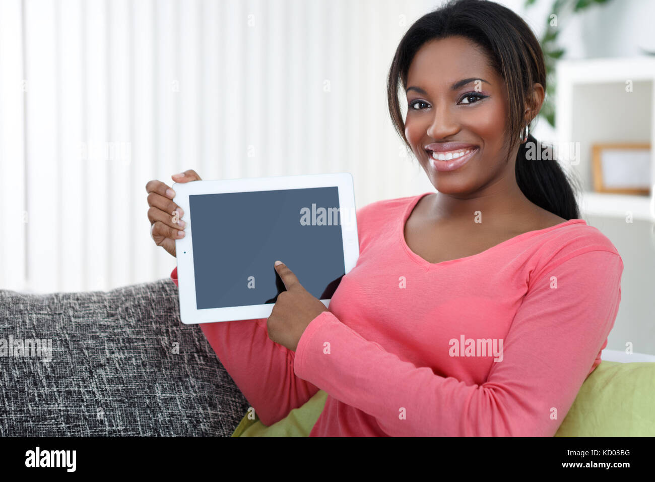 Smiling African woman pointing at empty tablet screen Stock Photo - Alamy