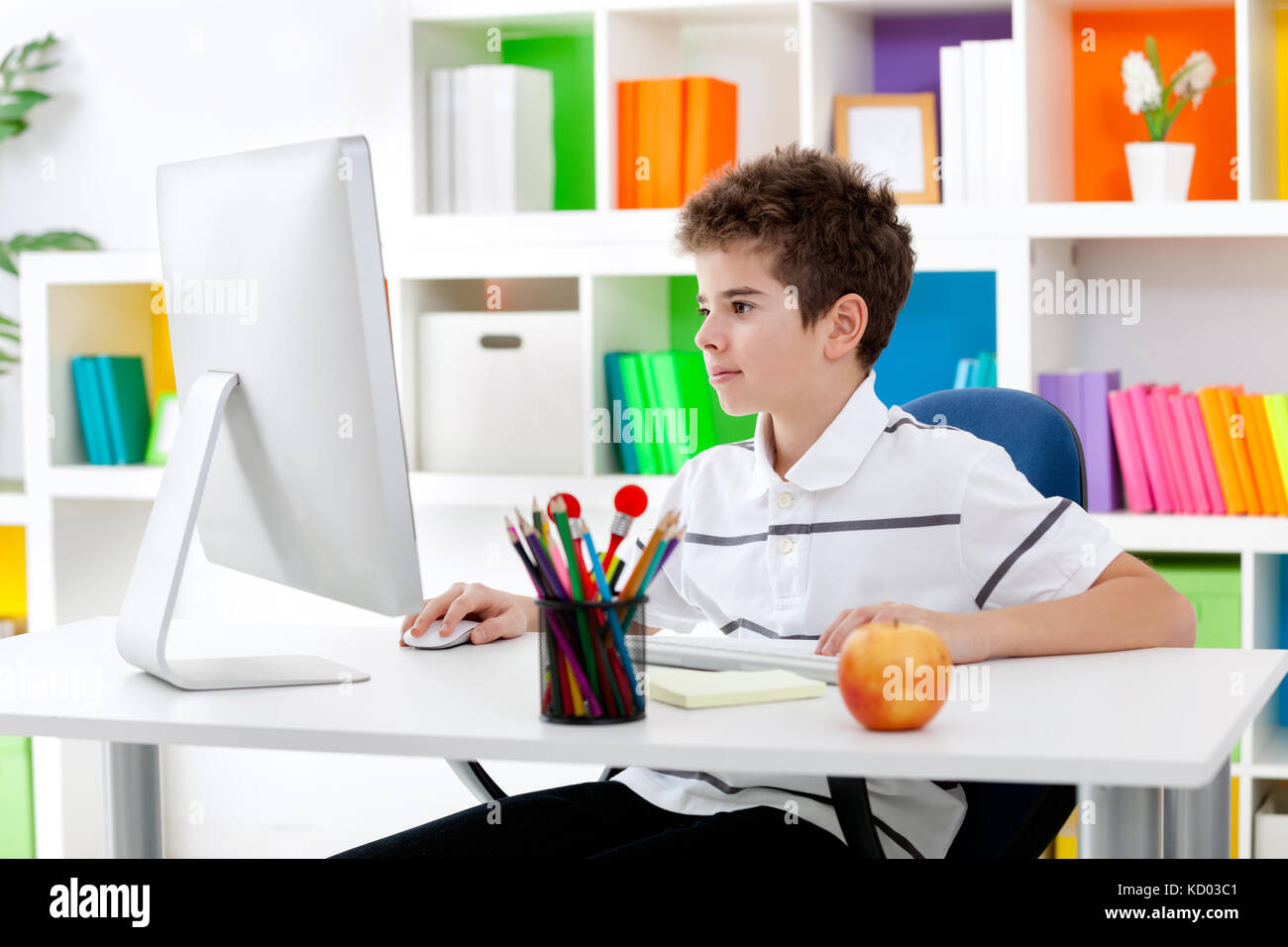 Concentrated young boy using computer in his room Stock Photo