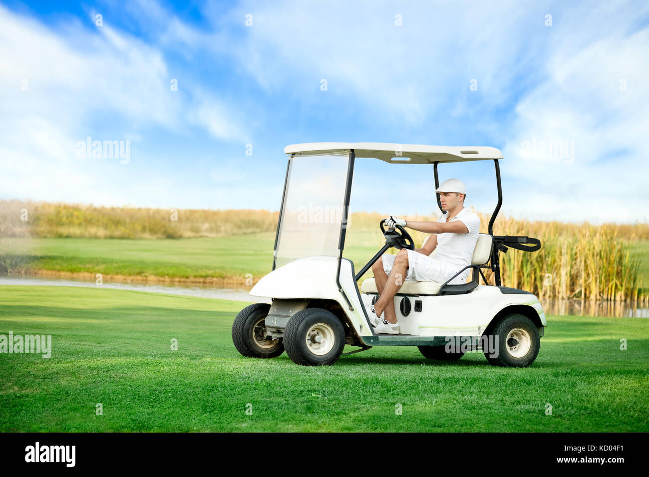 Young man driving golf buggy on golf course Stock Photo Alamy
