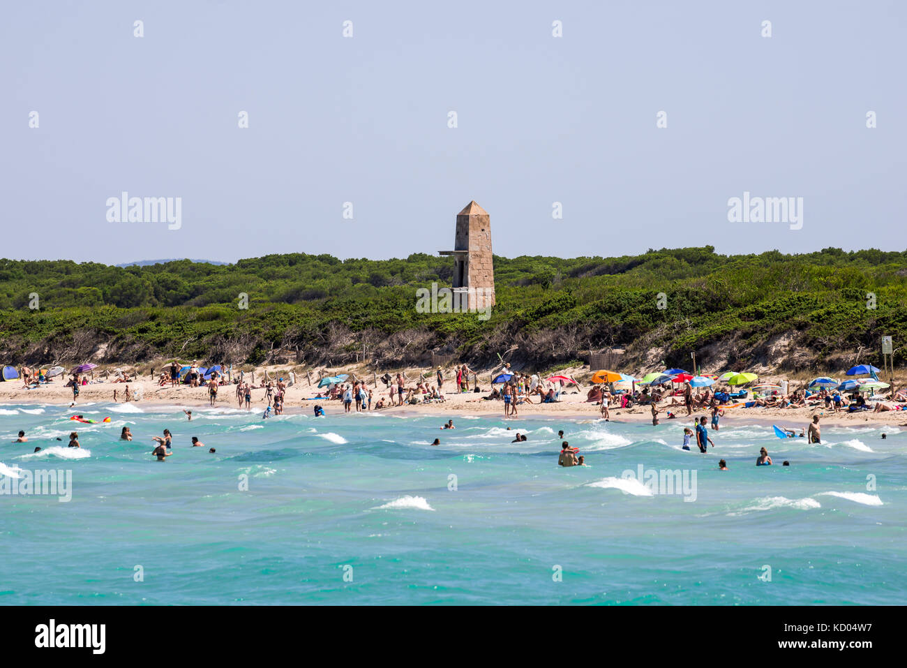 Alcudia pins tower and tourist swimming in Playa de Muro beach, northern part of Majorca island Stock Photo