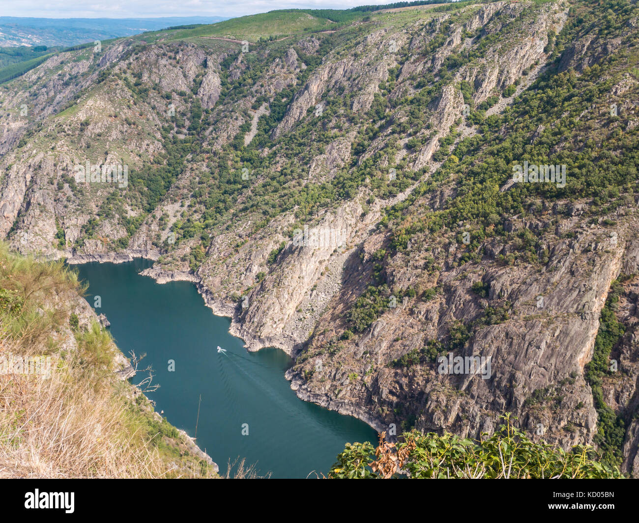 Catamaran in the canyon of Sil river in the province of Ourense, Galicia, Spain. Ribeira Sacra deep canyon landscape view from Vilouxe viewpoint. Stock Photo