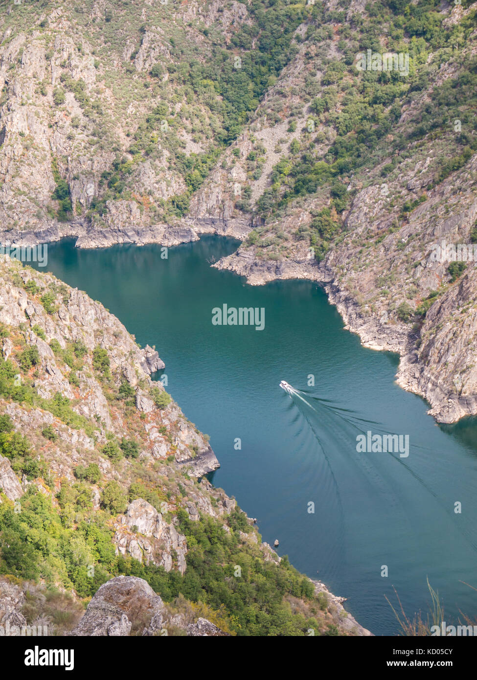 Excursion boat in the canyon of Sil river in the province of Ourense, Galicia, Spain. Ribeira Sacra deep canyon landscape view from Vilouxe viewpoint. Stock Photo