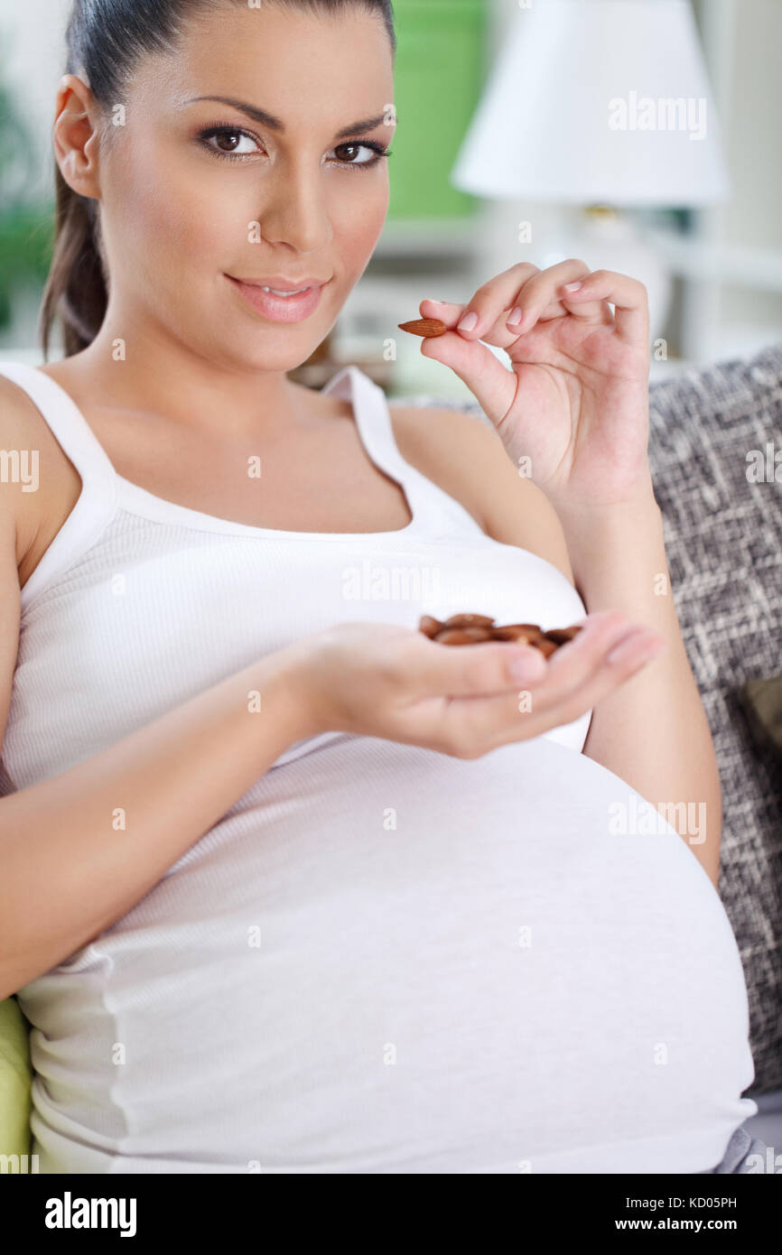 Pregnant woman eating almond, healthy eating of pregnant women Stock
