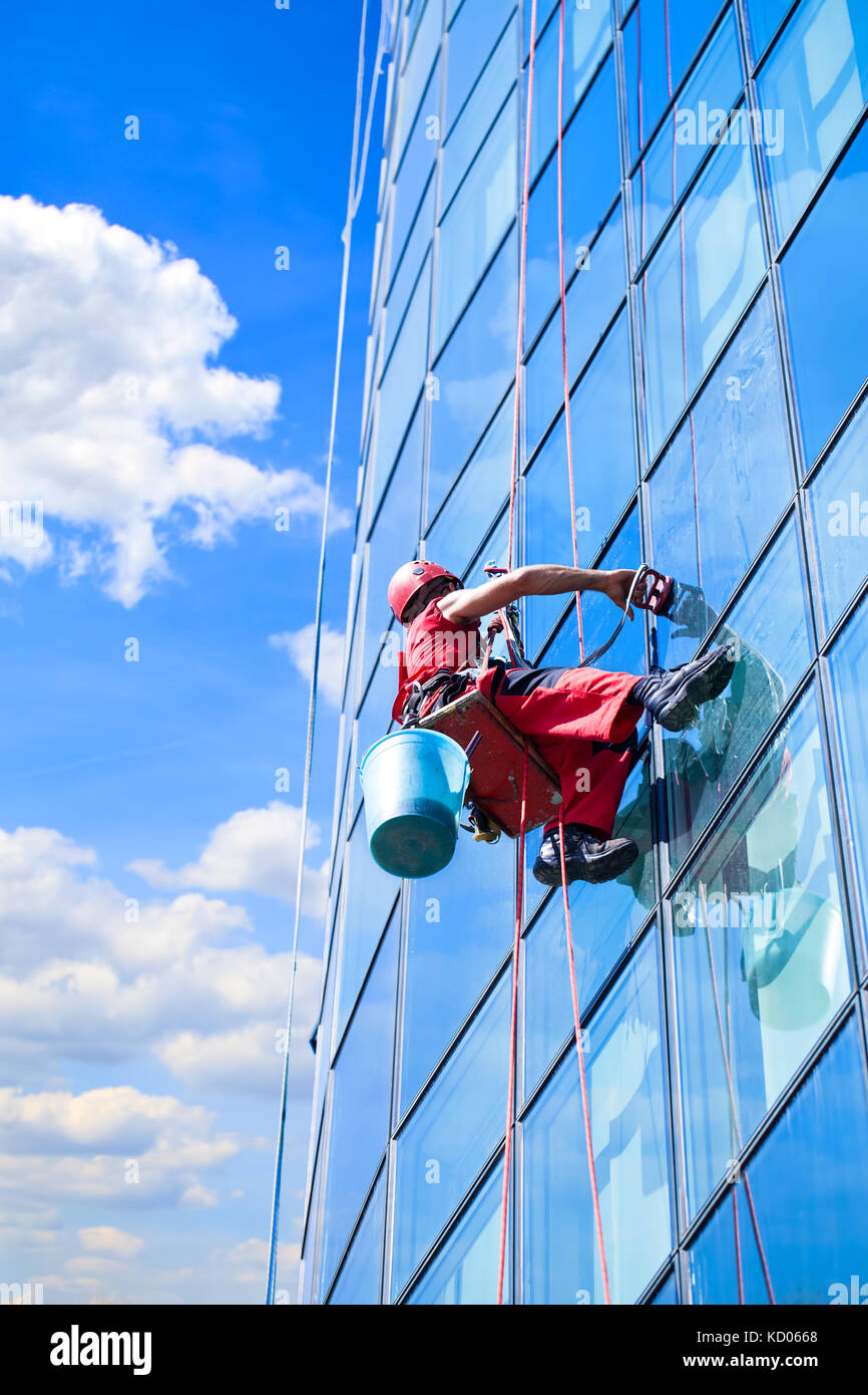 Window washer at work and reflect the sky in the windows Stock Photo