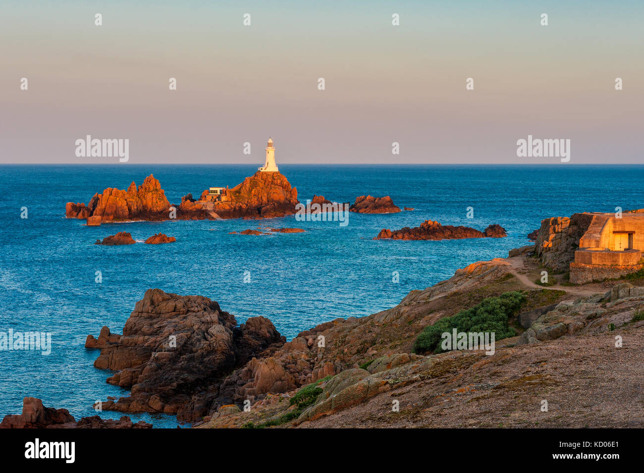 La Corbiere Lighthouse in Saint Helier, Jersey, Channel Islands, UK at sunrise and high tide Stock Photo
