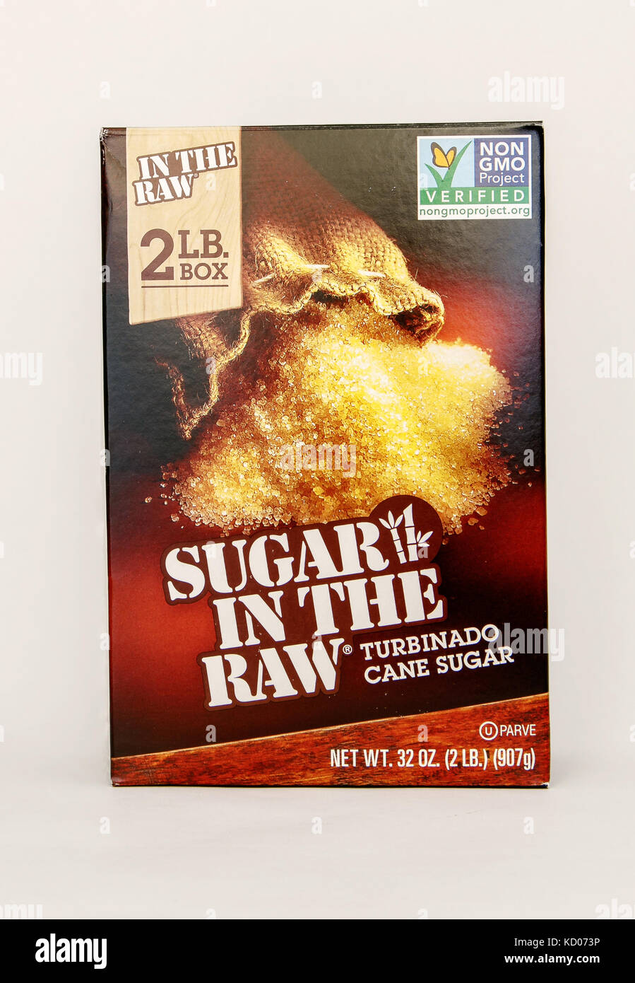 Package of cane brown sugar stands against white background. Stock Photo