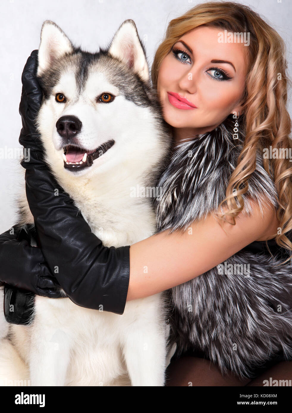 Portrait of a young attractive woman with a husky dog over grey background Stock Photo Alamy