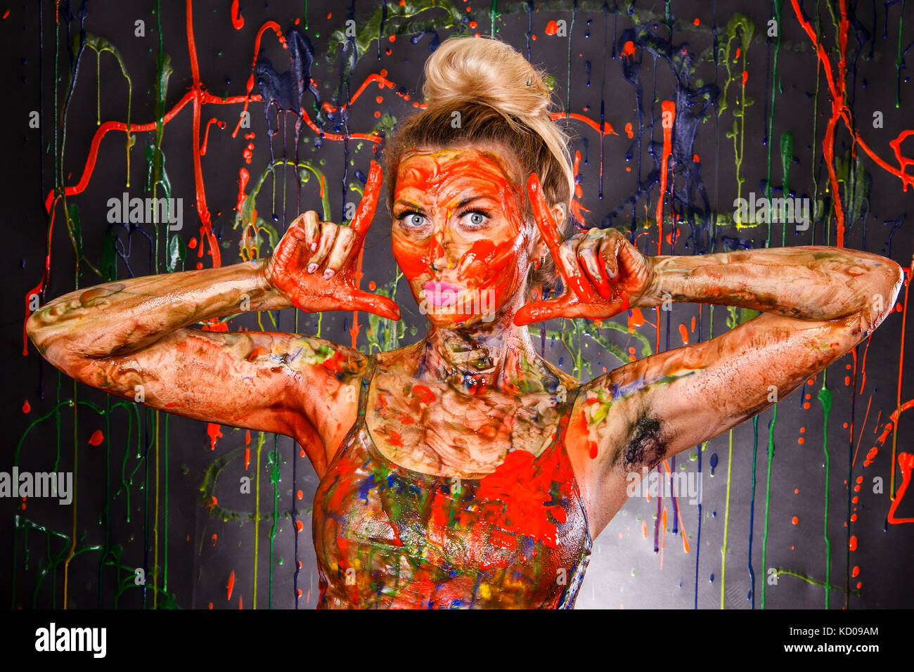 Beautiful young woman covered with multicolored paints Stock Photo