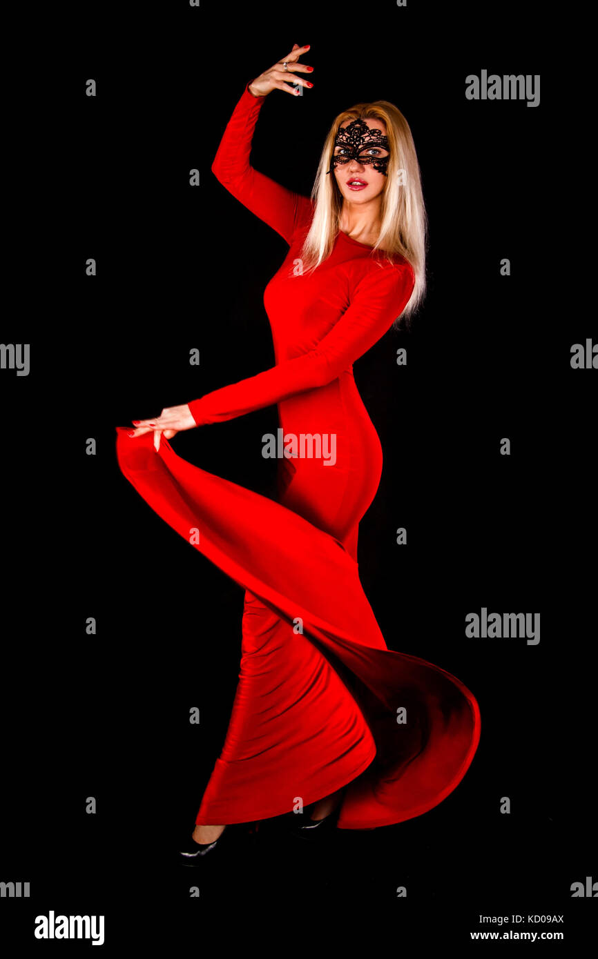 Gorgeous lady in a long red dress dancing over black background Stock ...