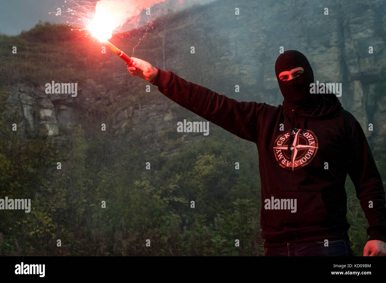 Eastern European Football Hooligan Stands with a lit flare gun. Stock Photo