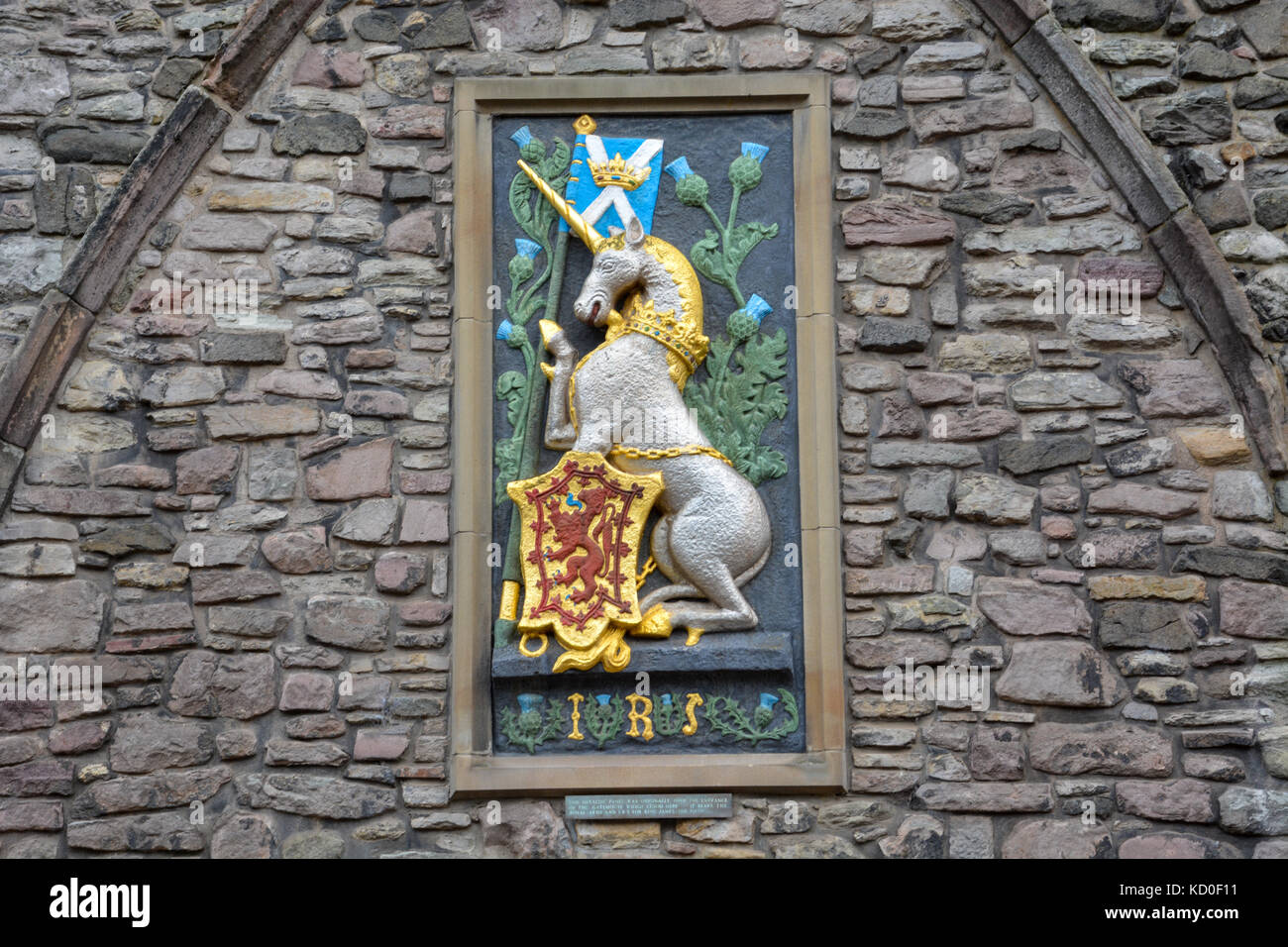 Unicorn with the Scottish flag and an emblem with a red lion on gold on a stone wall Stock Photo
