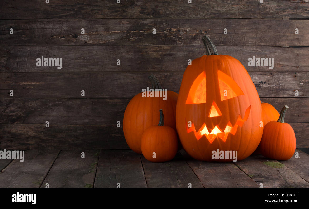 Glowing Halloween pumpkin heads jack o lantern on wooden background ...