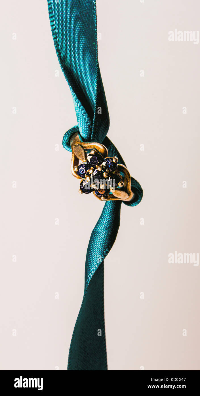 gold ring on teal ribbon Stock Photo