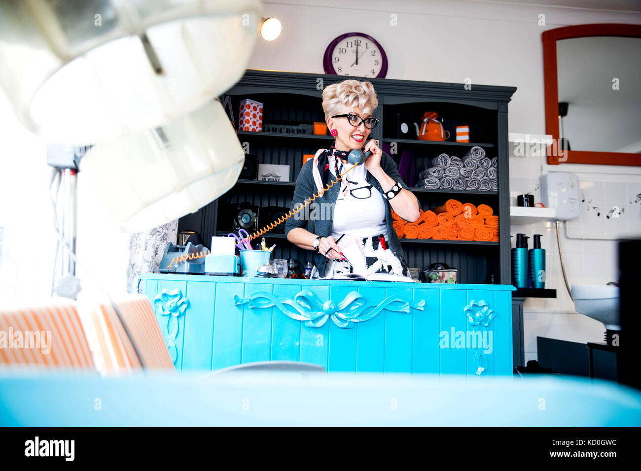 Woman at reception desk of quirky hair salon Stock Photo