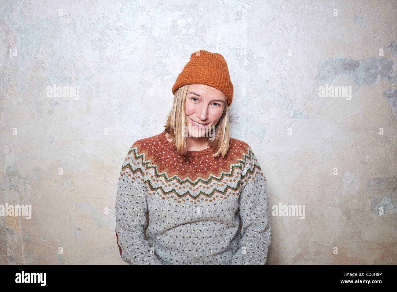 Portrait of woman wearing jumper and knitted hat, smiling Stock Photo