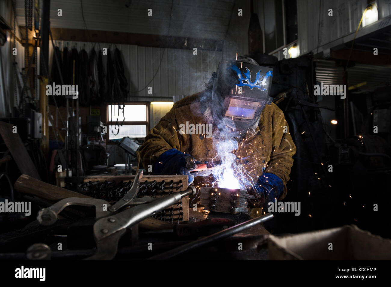 Blacksmith in welding mask welding metal in Stock Photo Alamy