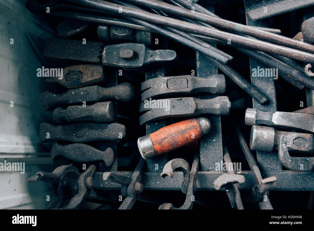 Overhead view of blacksmith tongs and hammers in workshop Stock Photo