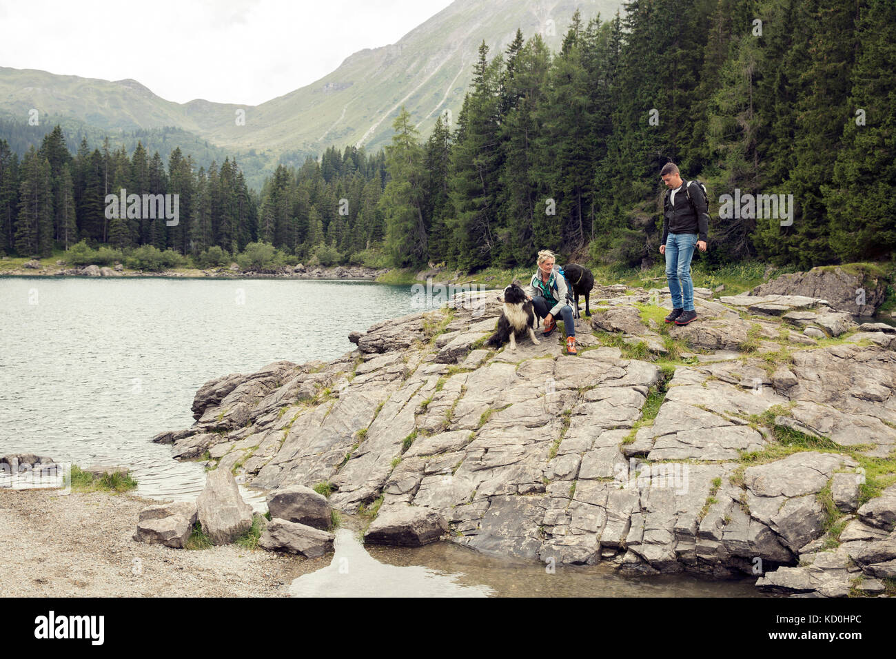Couple with dogs hiking by lake, Tirol, Steiermark, Austria, Europe Stock Photo