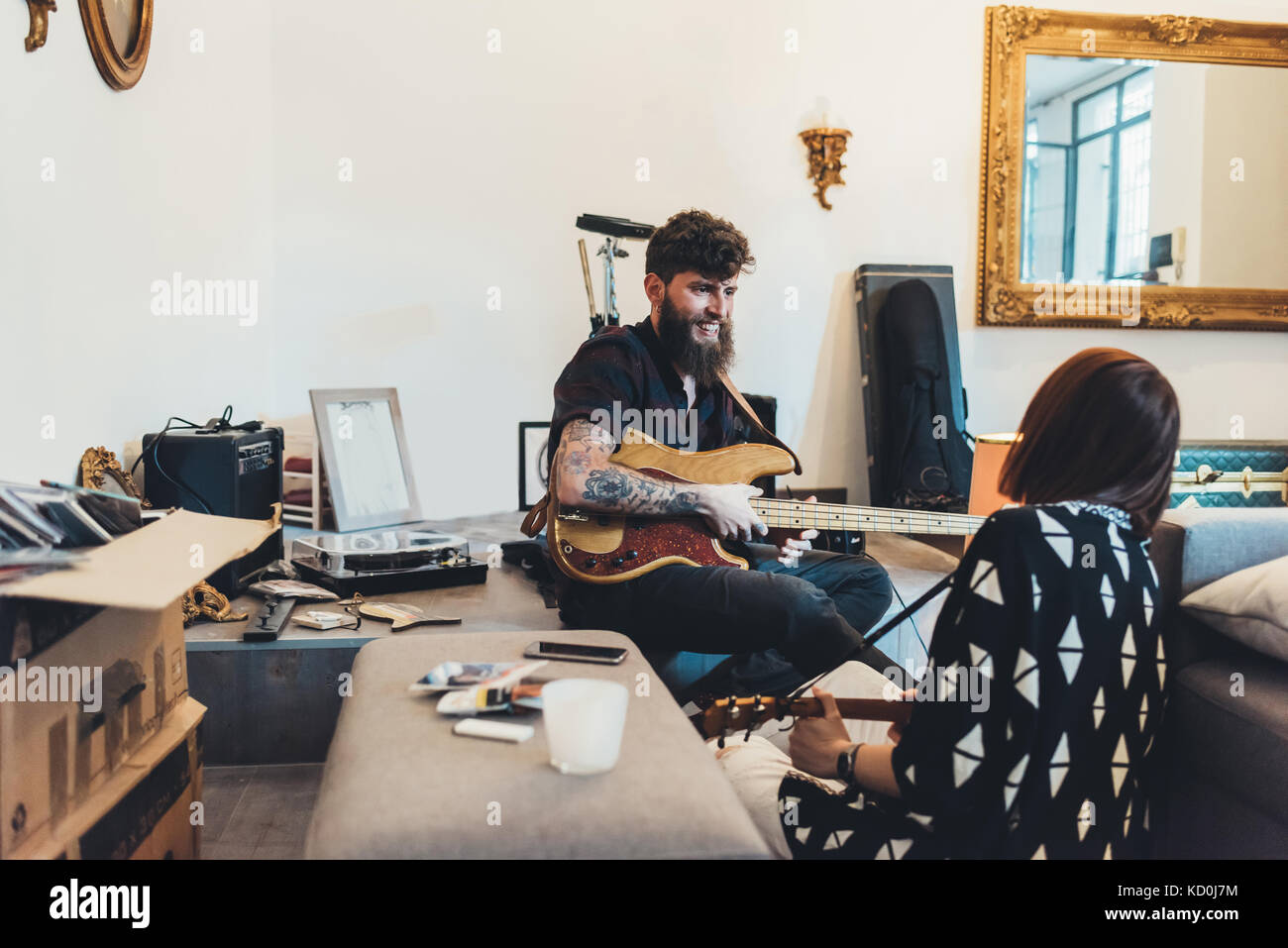 Couple playing electric guitars in apartment Stock Photo Alamy