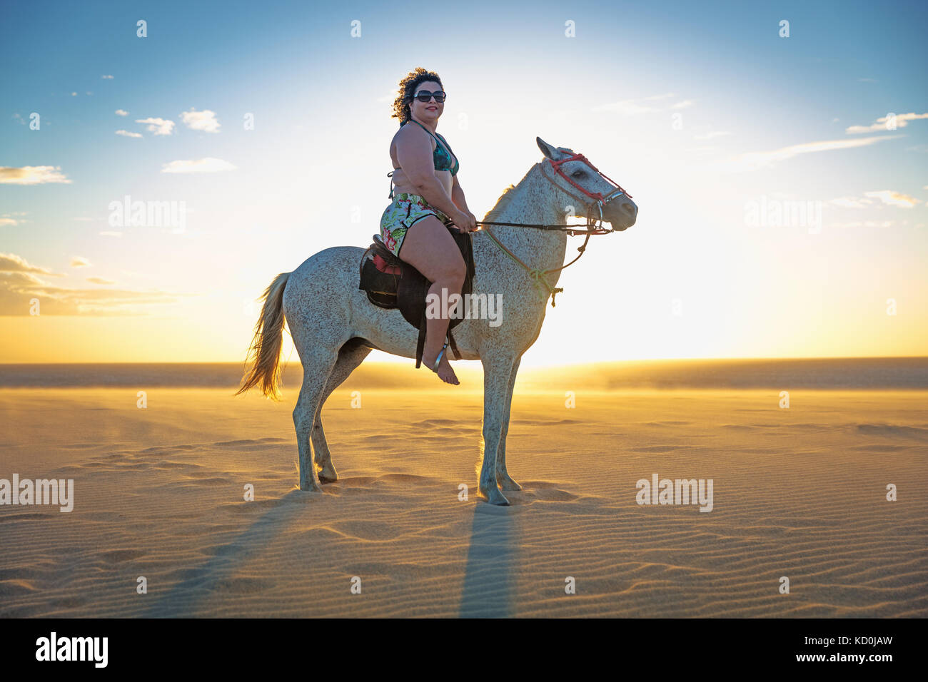 Woman riding horse on beach, side view, Jericoacoara, Ceara, Brazil, South America Stock Photo