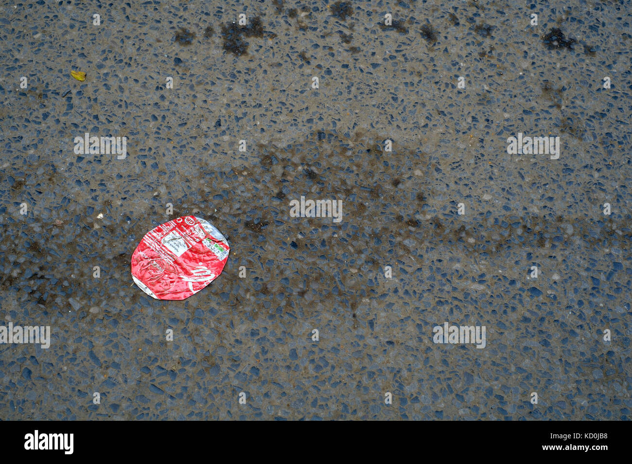flattened empty coca cola can flattened against the road tarmac england uk Stock Photo