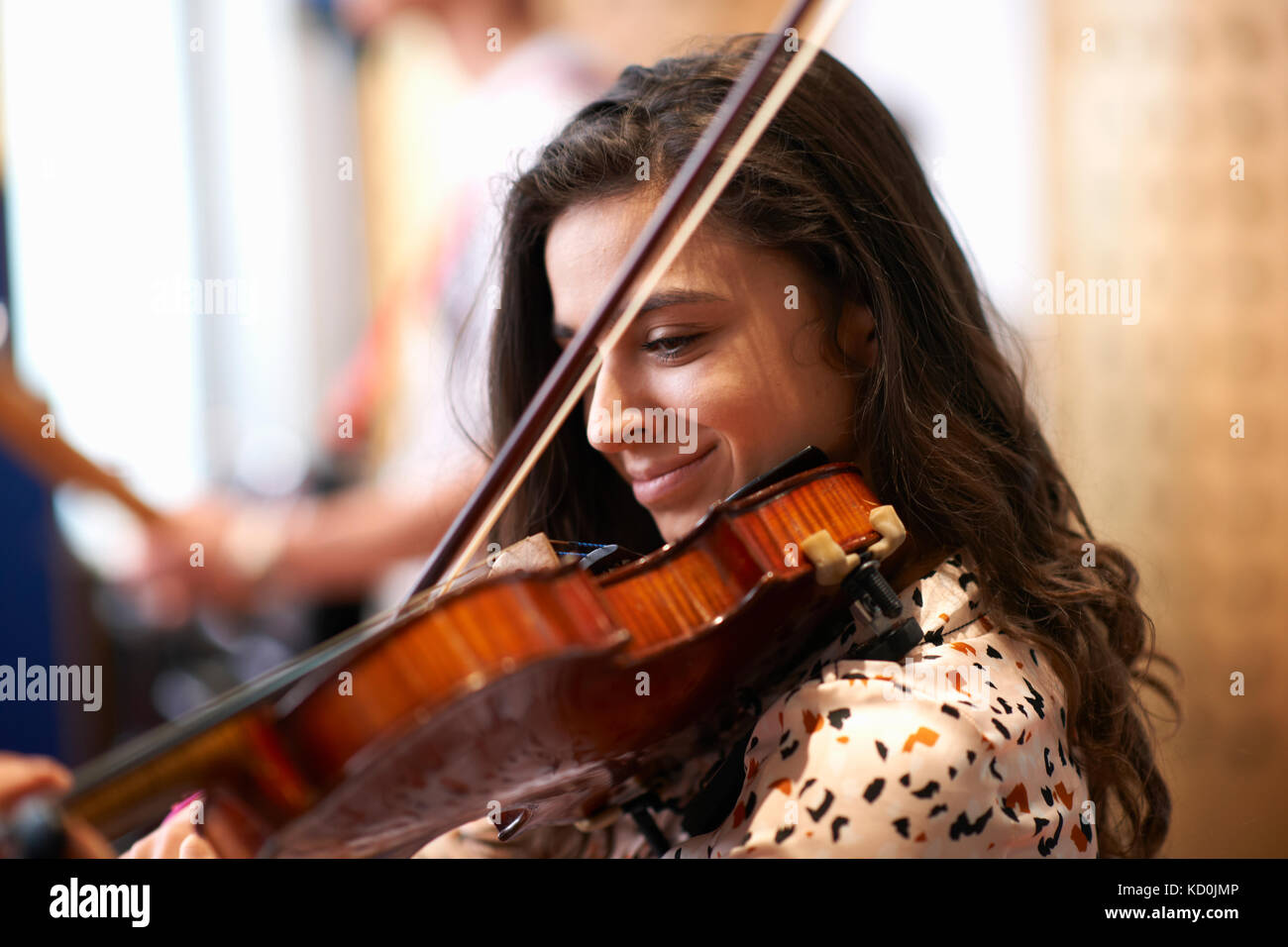 Young female college student playing violin in recording studio Stock Photo