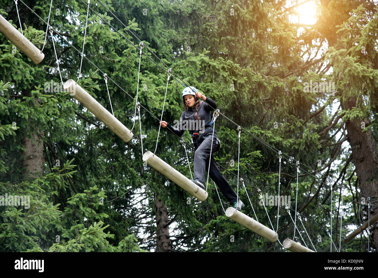 Teenage girl on high rope course Stock Photo