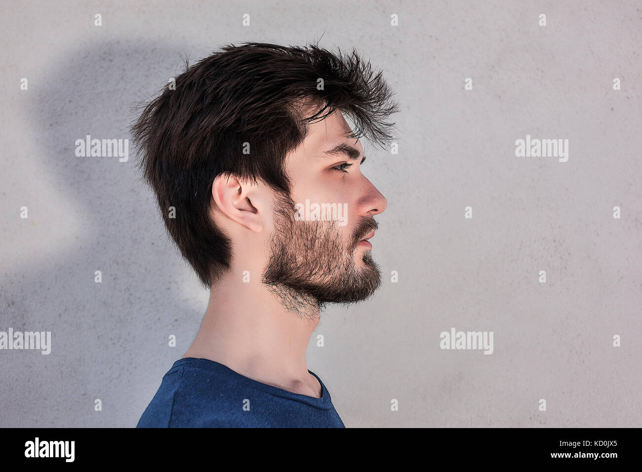 Head and shoulder side view portrait of young man with beard Stock Photo