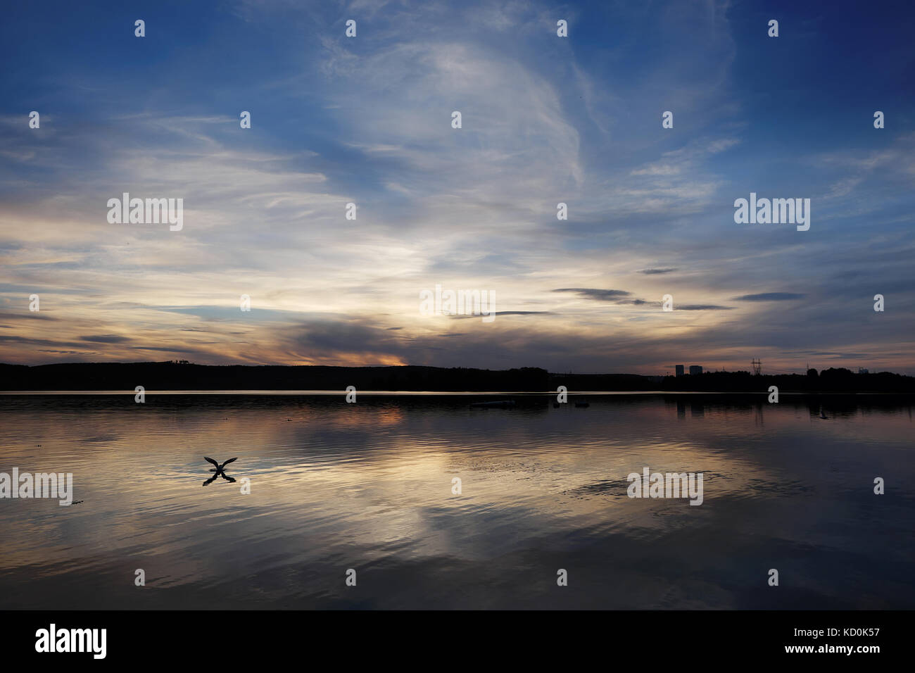 Sunset on the city pond with the reflection of the sky in the water and ...