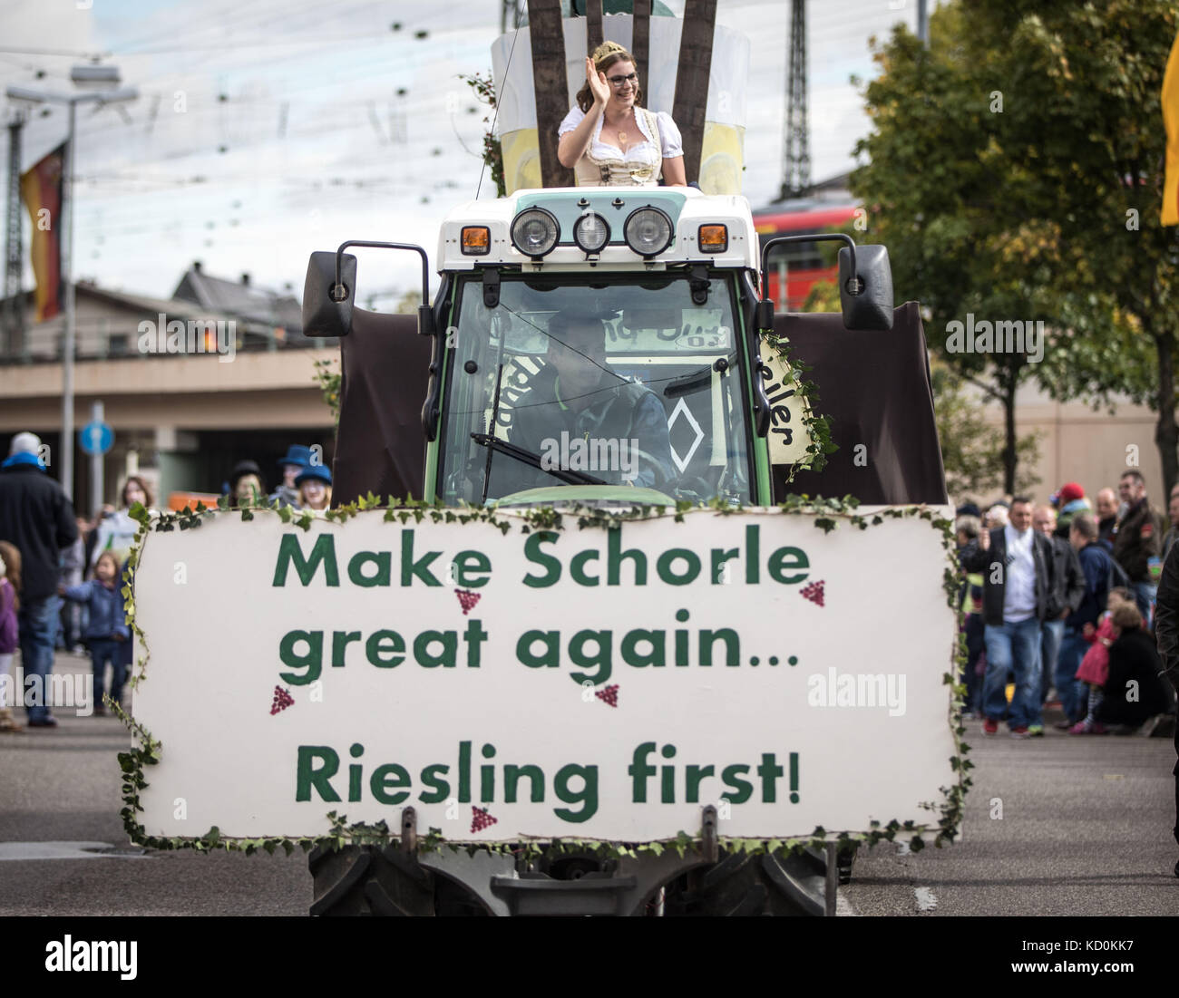 A wagon with a sign reading 'Make Schorle great again. Riesling first!' drives through the streets during the Vintner's Festive Parade in Neustadt an der Weinstraße, Germany, 8 October 2017. Photo: Frank Rumpenhorst/dpa Stock Photo