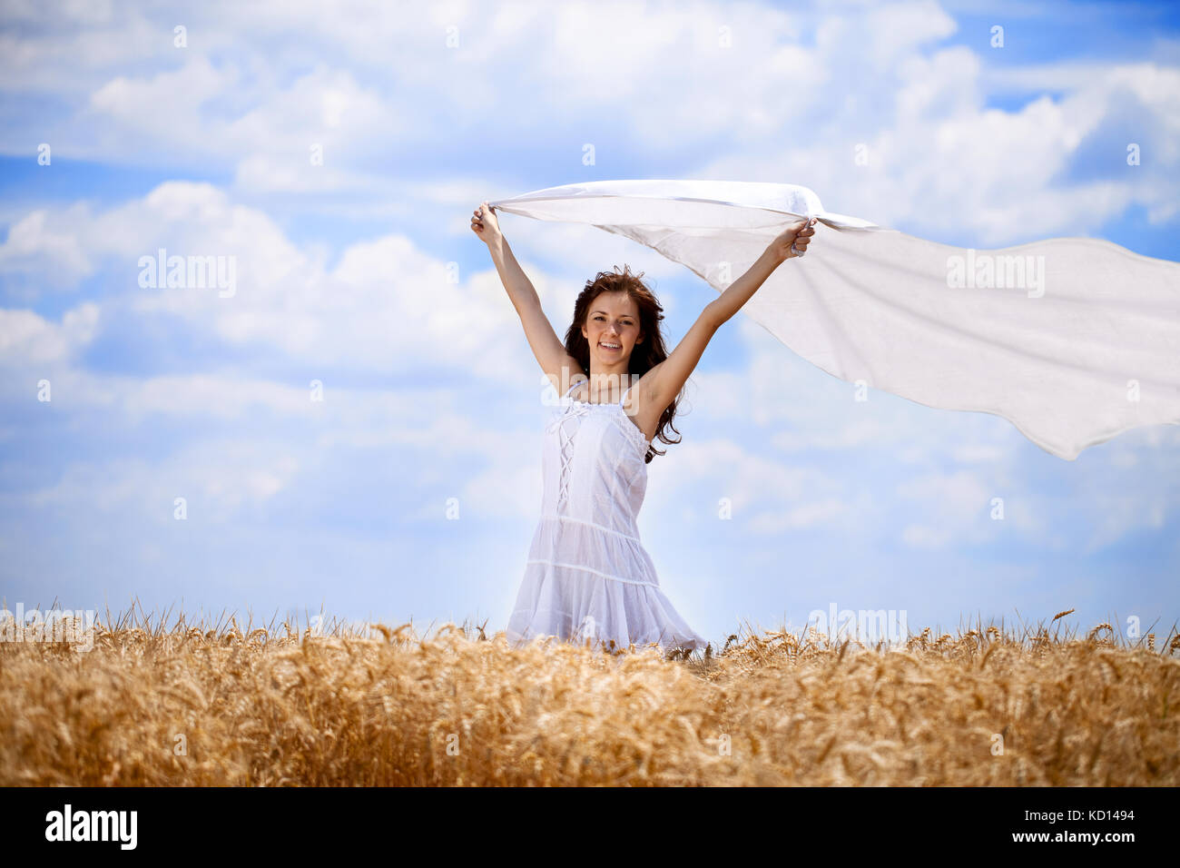 Pretty woman in golden wheat field with flying scarf Stock Photo - Alamy