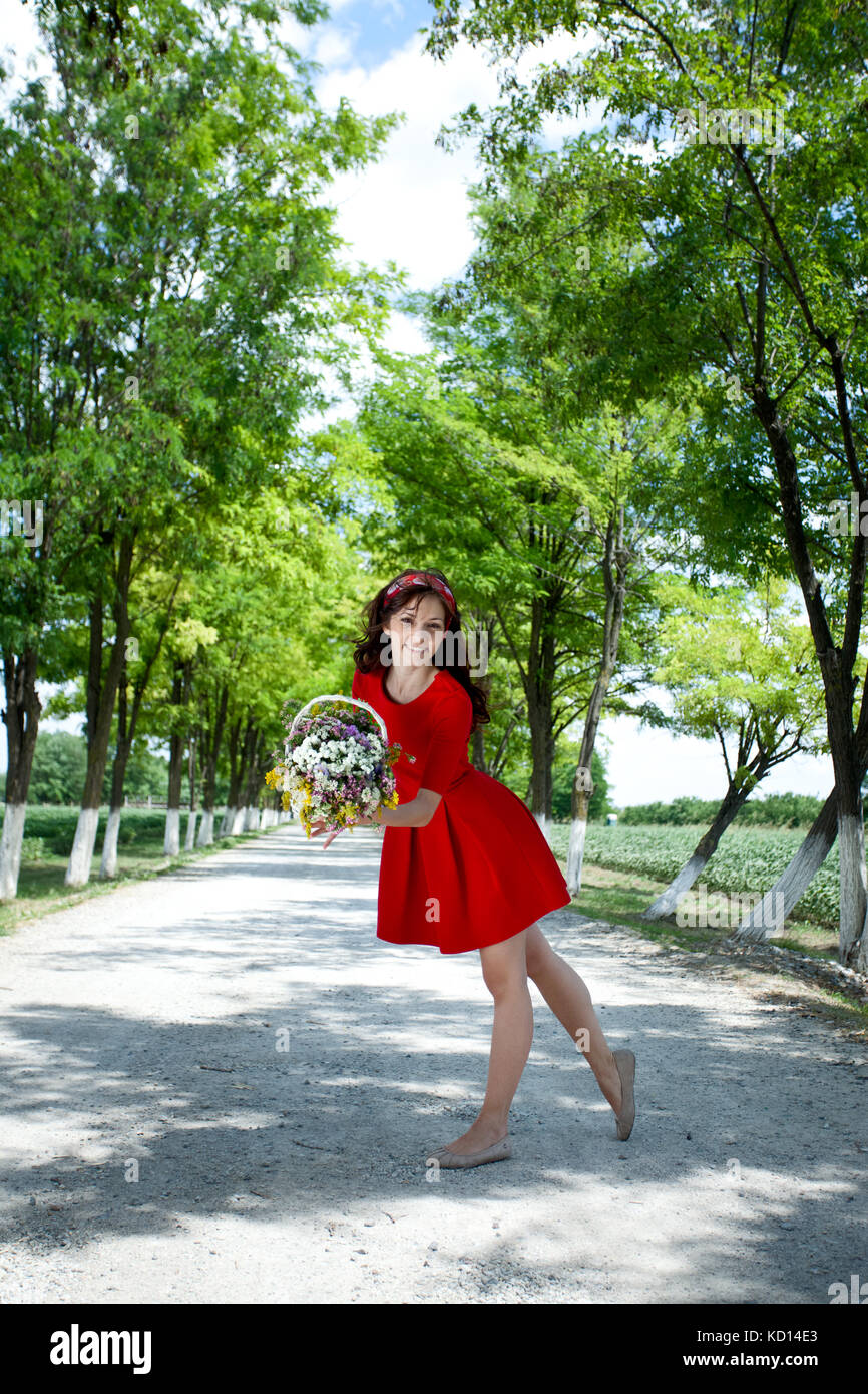 young woman holding basket with flowers outside Stock Photo - Alamy