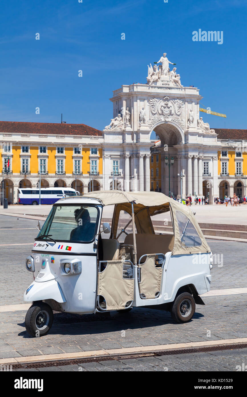 Lisbon, Portugal - August 12, 2017: White Tuk Tuk taxi cab with driver stands on Commerce Square in Lisbon. Piaggio Ape three-wheeled light commercial Stock Photo