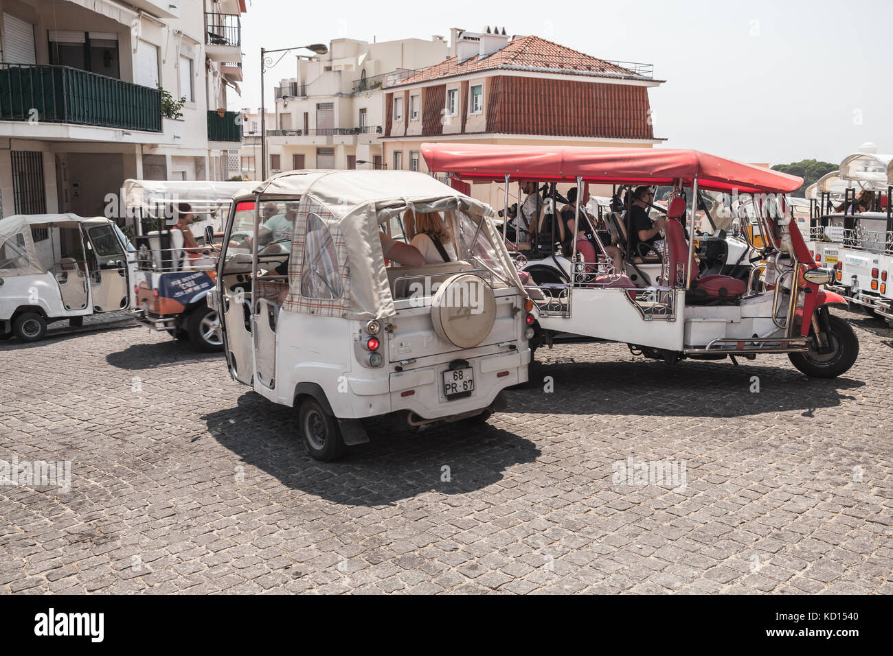 Lisbon, Portugal - August 13, 2017: Tuk Tuk taxi cabs of Lisbon stand on a city square with tourists as a passengers. Piaggio Ape three-wheeled light  Stock Photo