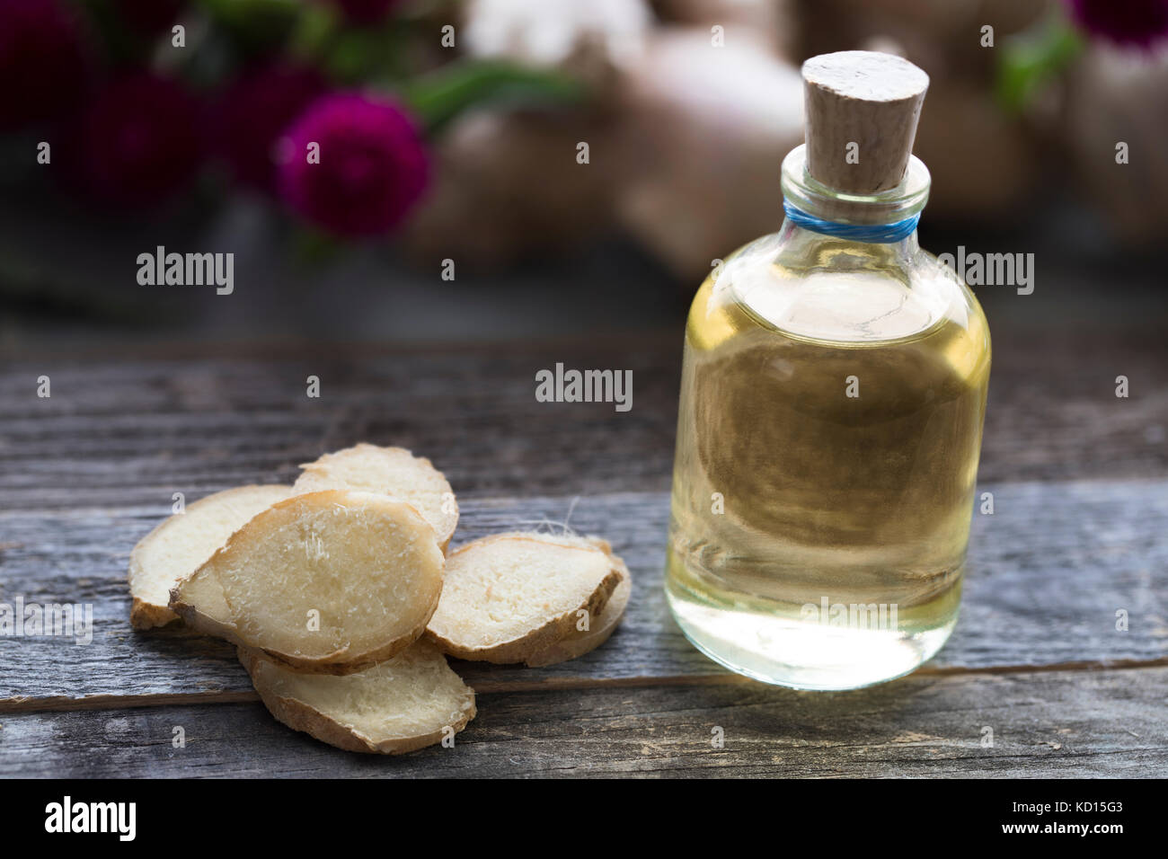 Bottle of ginger oil with ginger slices. Stock Photo