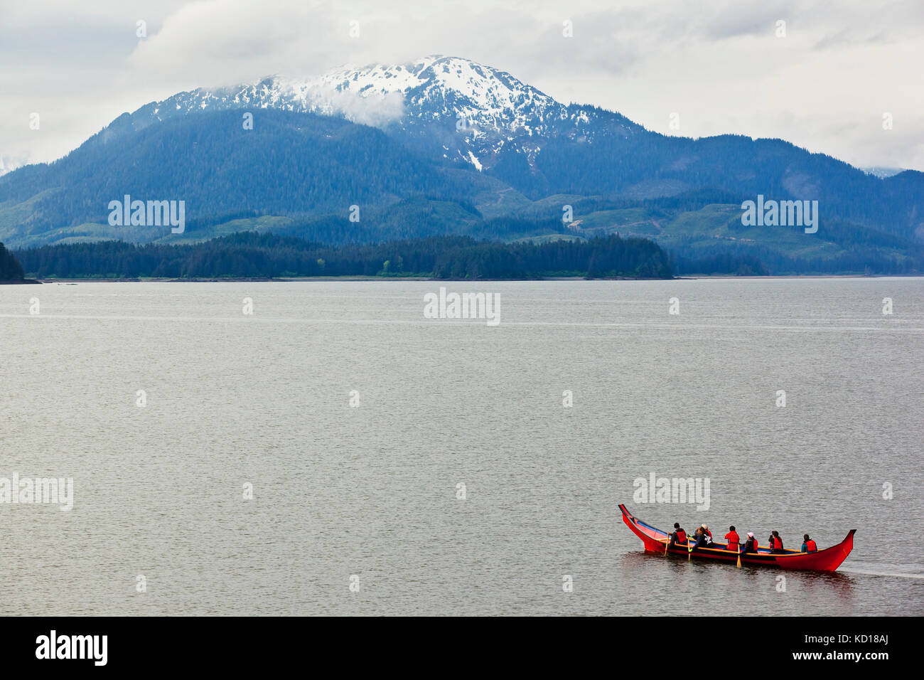 Hoonah townsfolk paddling a traditional Tlingit dugout canoe along the shoreline of Icy Strait Point, Alaska, U.S.A. Stock Photo