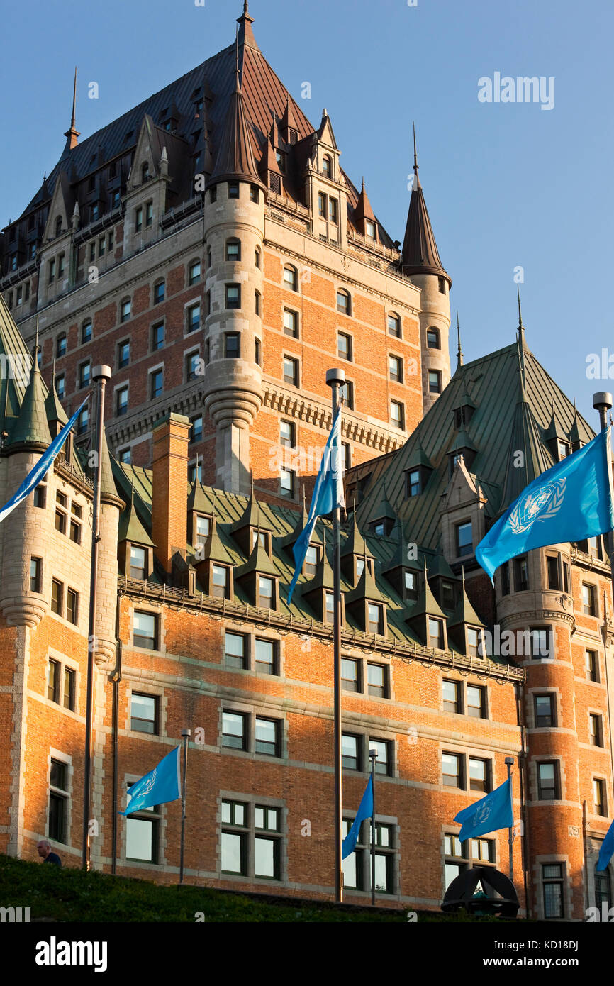 Western facade of Chateau Frontenac in the Upper Town (Haute Ville) of Old Quebec City. In the foregrown are flags of UNESCO (United Nations Educational, Scientific and Cultural Organization), Quebec City, Quebec, Canada Stock Photo