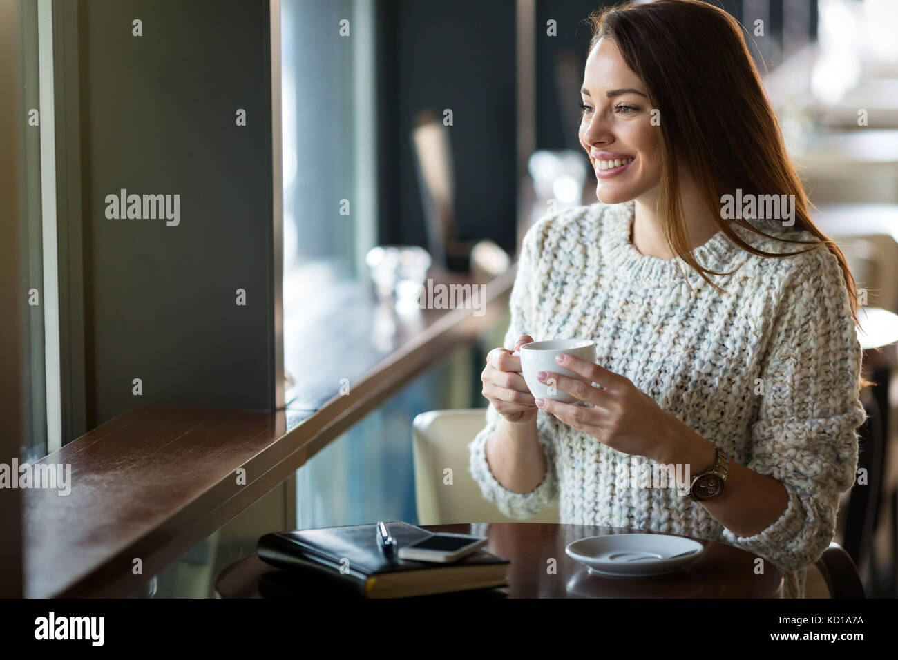 Beautiful woman drinking coffee in restaurant alone Stock Photo