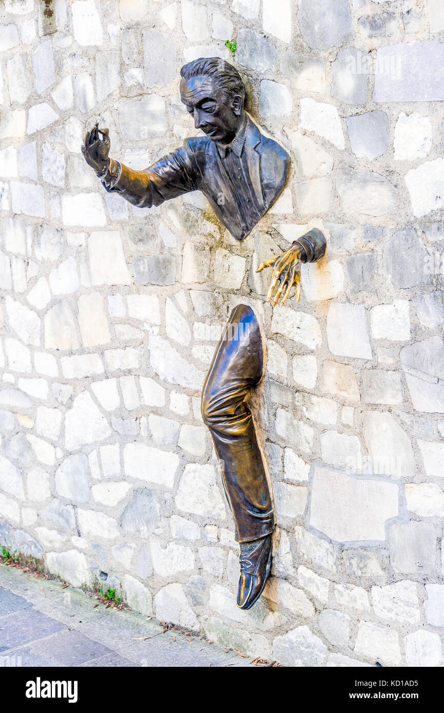 The Passe-Muraille, stucked into the wall of the Marcel Aymé place, is a statue made by the actor Jean Marais, as a tribute to Marcel Aymé. Stock Photo