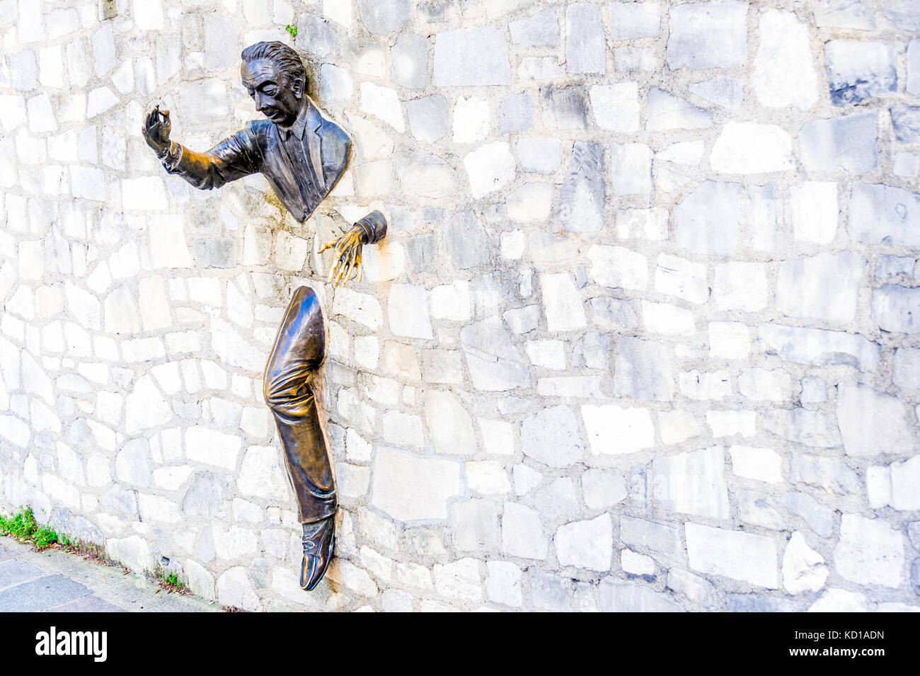 The Passe-Muraille, stucked into the wall of the Marcel Aymé place, is a statue made by the actor Jean Marais, as a tribute to Marcel Aymé. Stock Photo