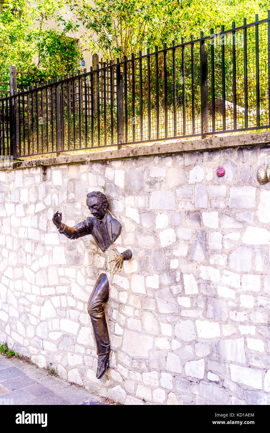 The Passe-Muraille, stucked into the wall of the Marcel Aymé place, is a statue made by the actor Jean Marais, as a tribute to Marcel Aymé. Stock Photo