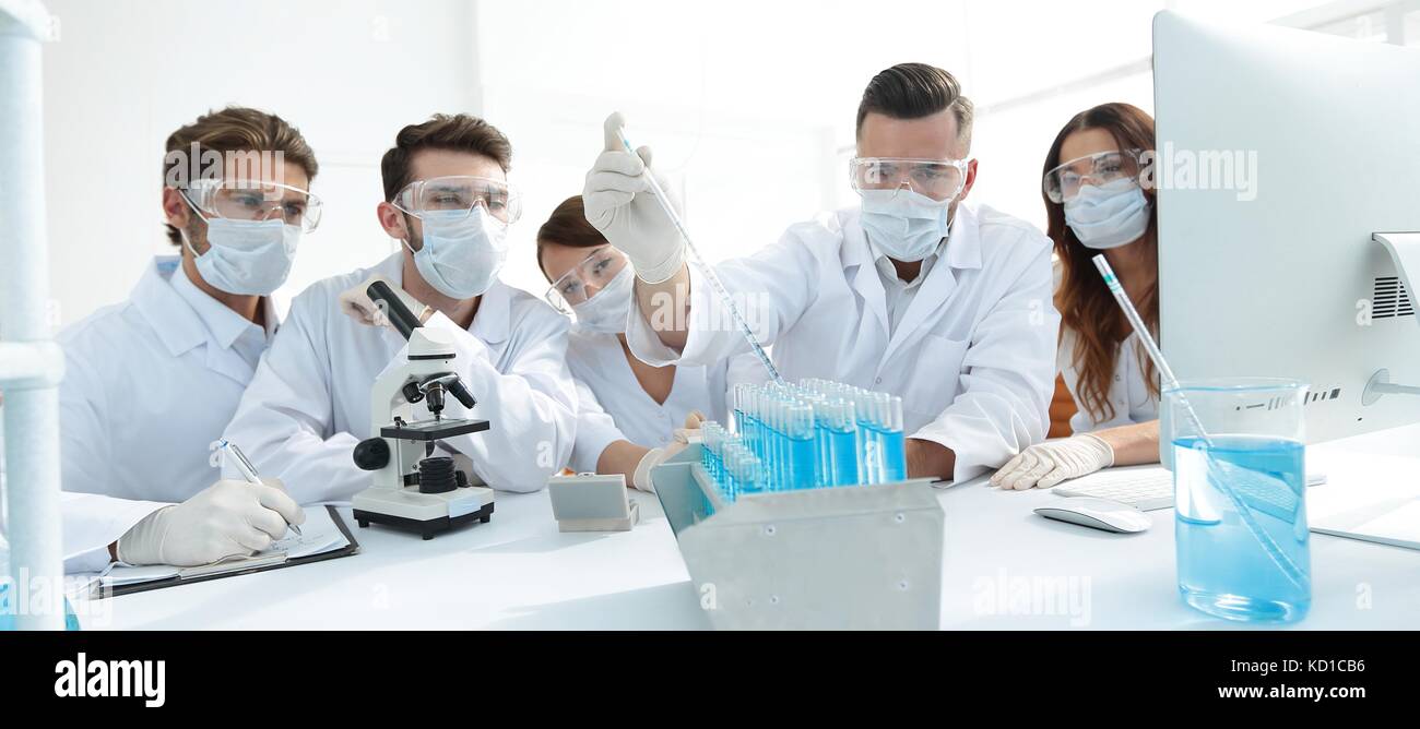 medical doctors are working with test tubes and microscope at the lab ...