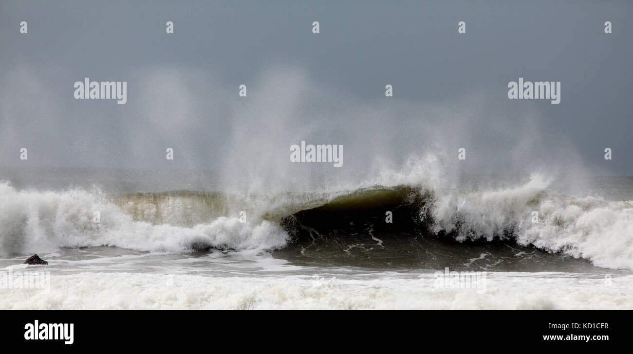 Waves crashing onto beach Stock Photo