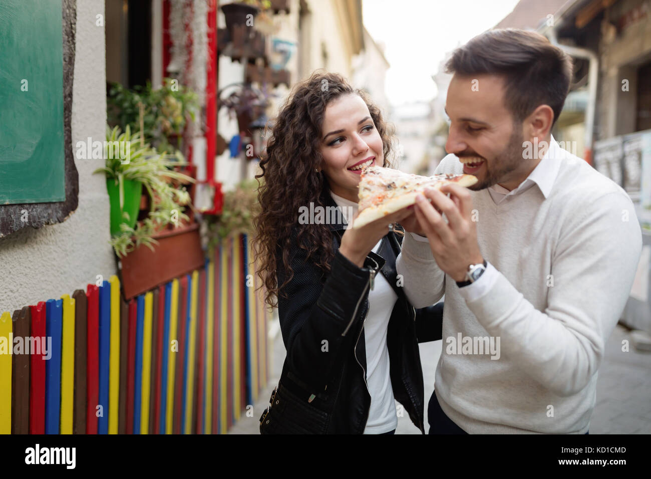 Happy young couple sharing one pizza cut Stock Photo