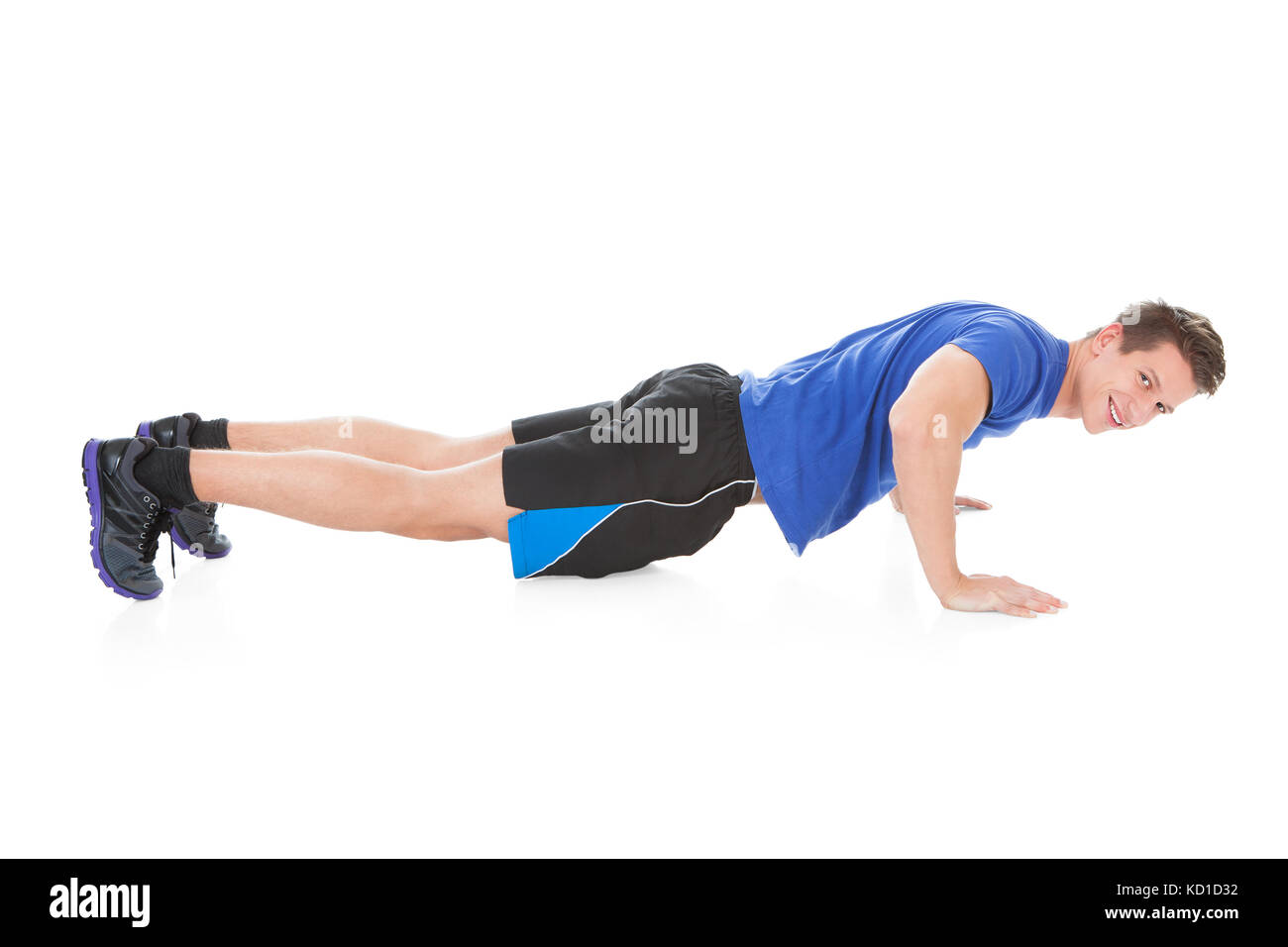 Portrait Of Young Man Doing Pushups On White Background Stock Photo