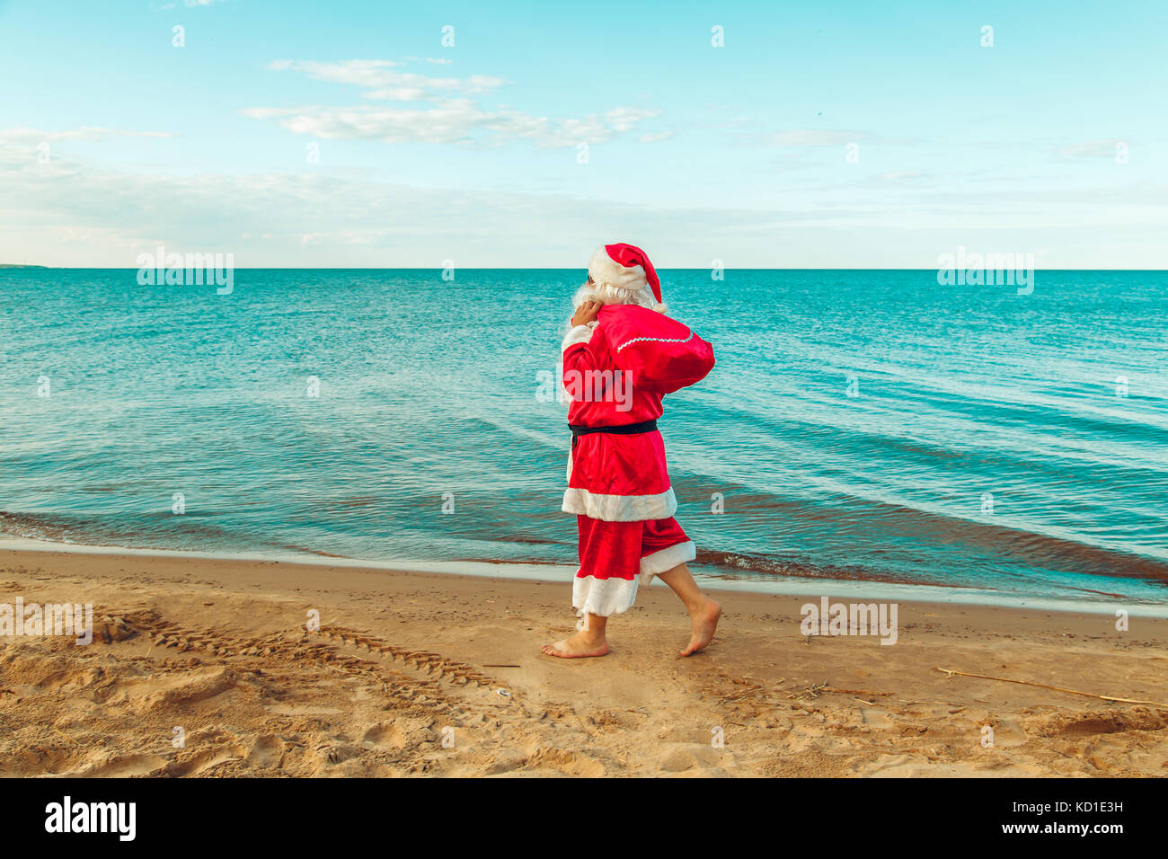 Santa Claus with a bag of gifts on the beach. The symbol of Christmas ...