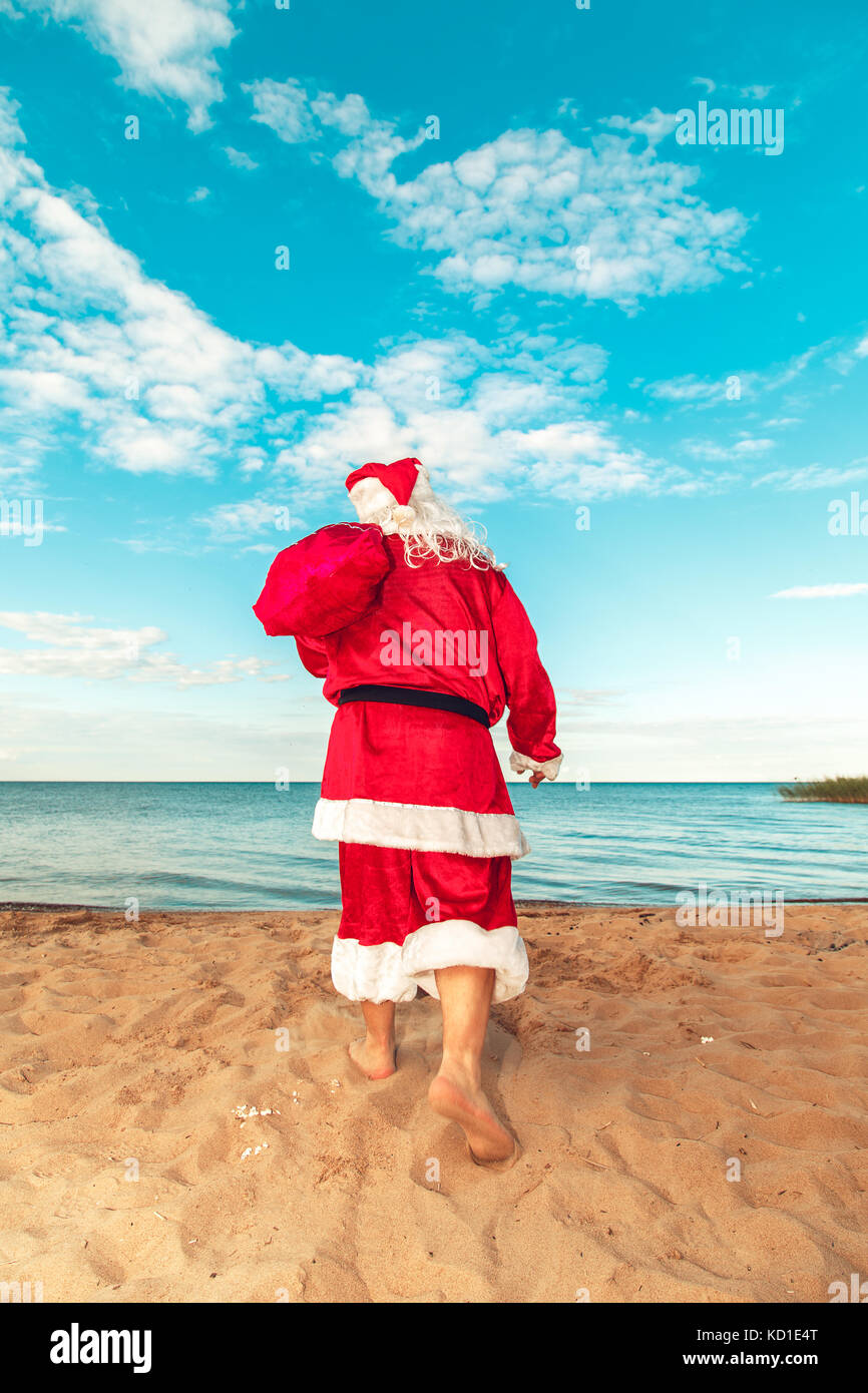 Santa Claus with a bag of gifts on the beach. The symbol of Christmas ...